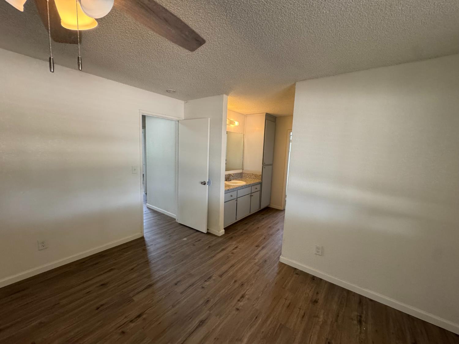 21293 East American Avenue Reedley, CA 93654 - Photo 9 of 19 a view of an empty room with wooden floor