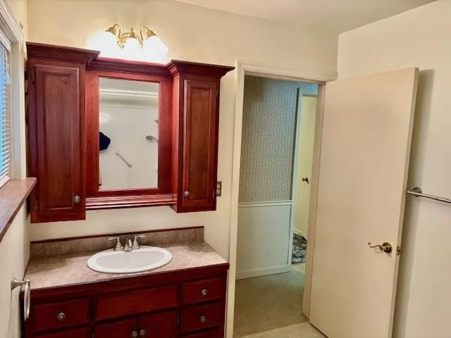 a bathroom with a granite countertop sink and a mirror