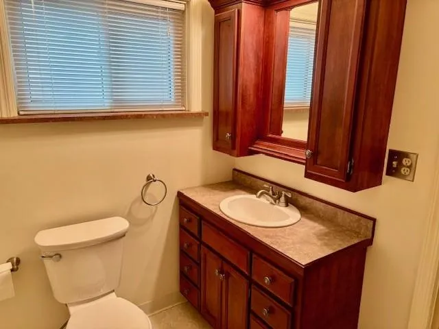 a bathroom with a toilet sink and mirror