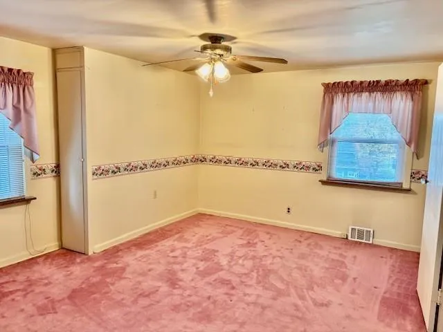 a view of a room with window and a ceiling fan
