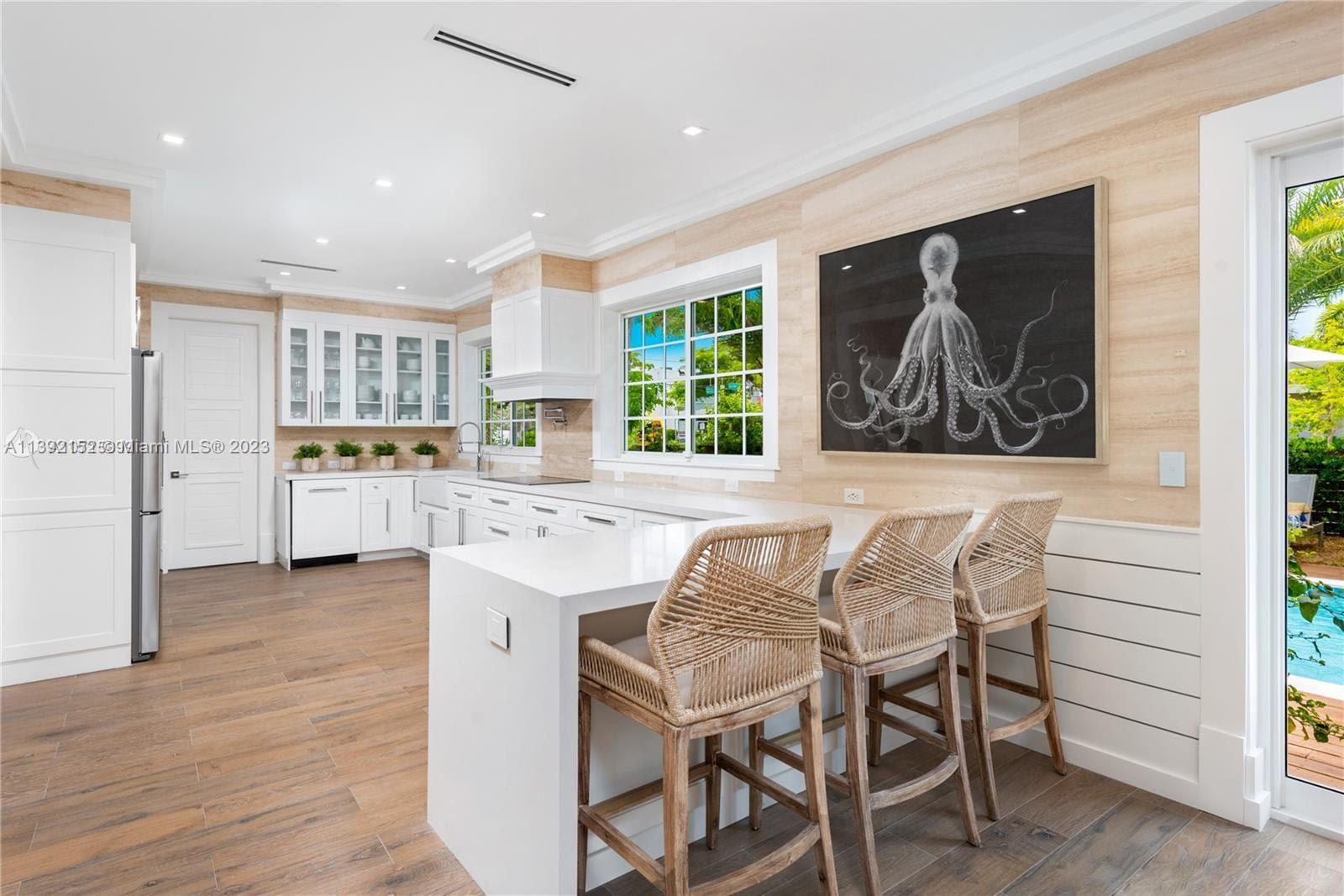 2575 Pine Tree Drive Miami Beach, FL 33140 - Photo 25 of 37 a kitchen with stainless steel appliances granite countertop a stove and a refrigerator