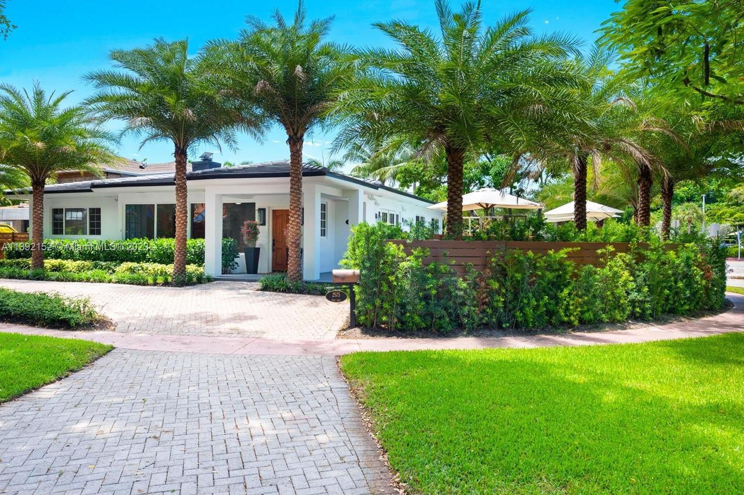 2575 Pine Tree Drive Miami Beach, FL 33140 - Photo 3 of 37 a front view of a house with a garden