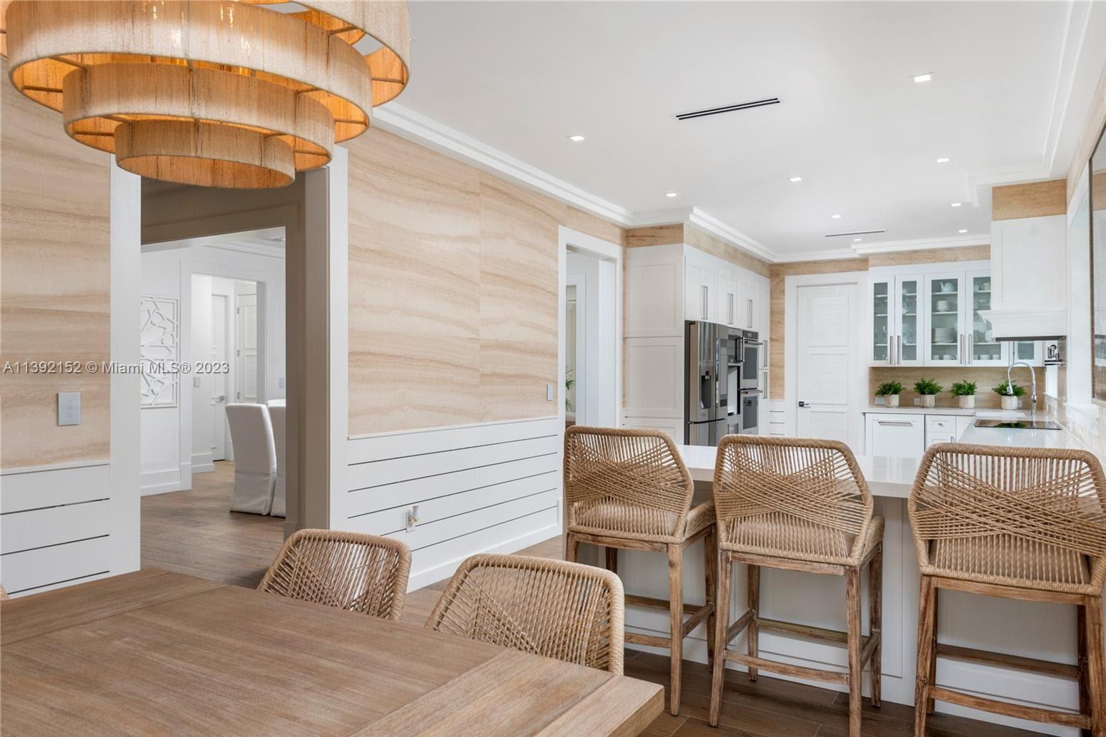 2575 Pine Tree Drive Miami Beach, FL 33140 - Photo 9 of 37 a dining room with furniture and a chandelier