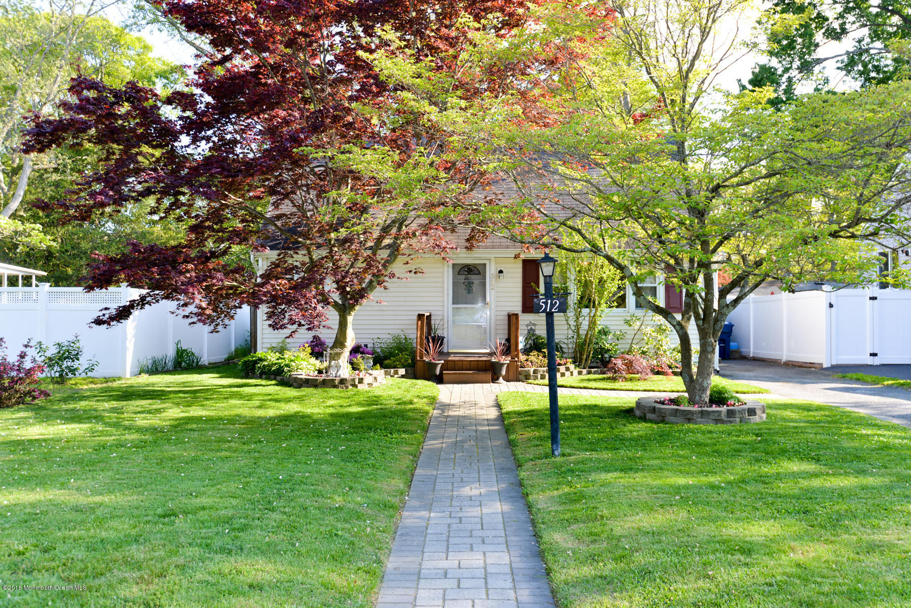 a front view of a house with a yard and trees