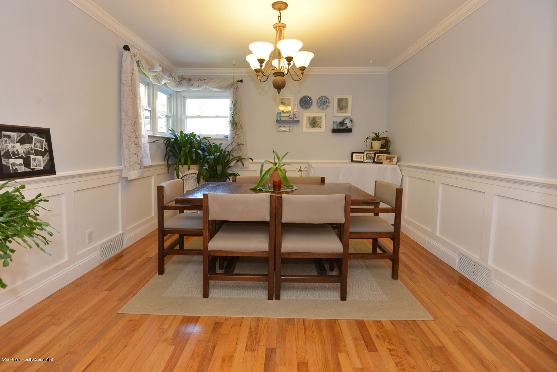 512 Lakewood Road Neptune Township, NJ 07753 - Photo 4 of 28 a dining room with wooden floor a chandelier a wooden table and chairs