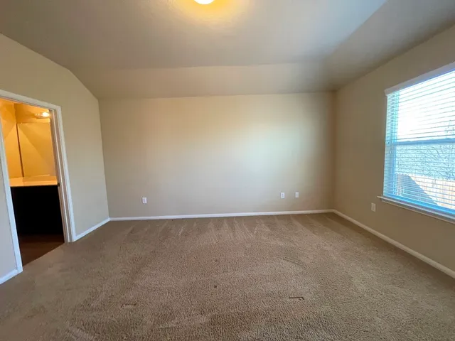 a bedroom with a bed and a flat tv screen on dresser