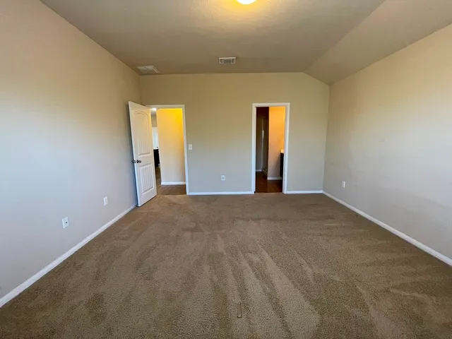 an empty room with windows and mirror