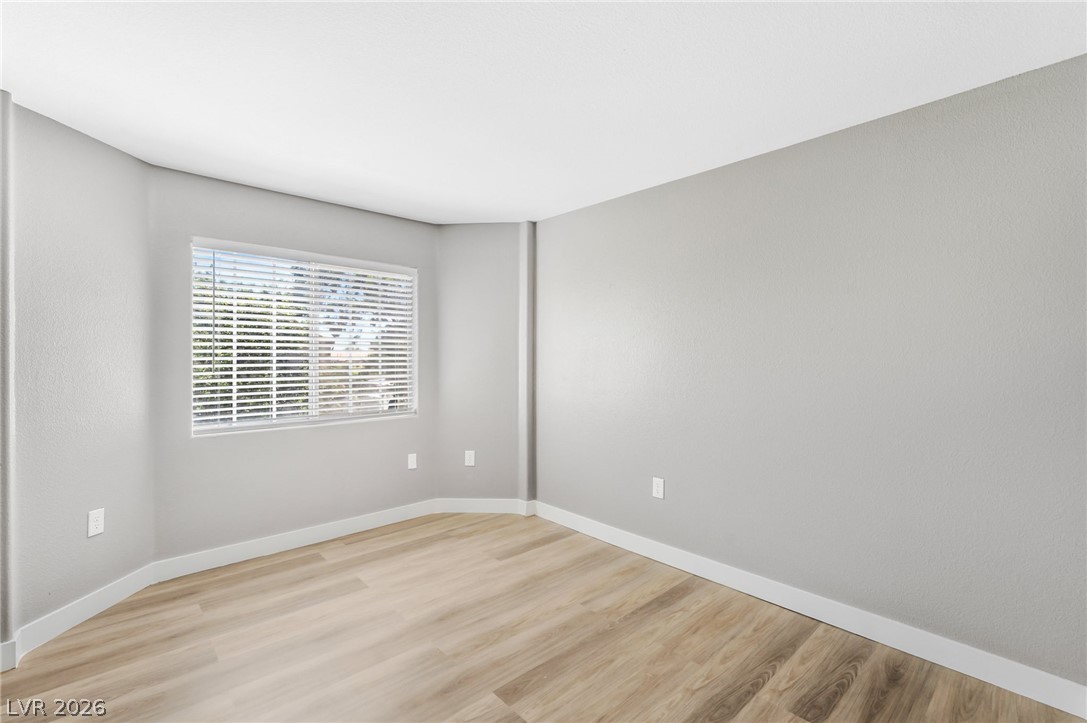3318 North Decatur Boulevard, Unit 2152 Las Vegas, NV 89130 - Photo 28 of 58 Natural light filters through blinds, illuminating the versatile wood-look flooring in this spacious room.