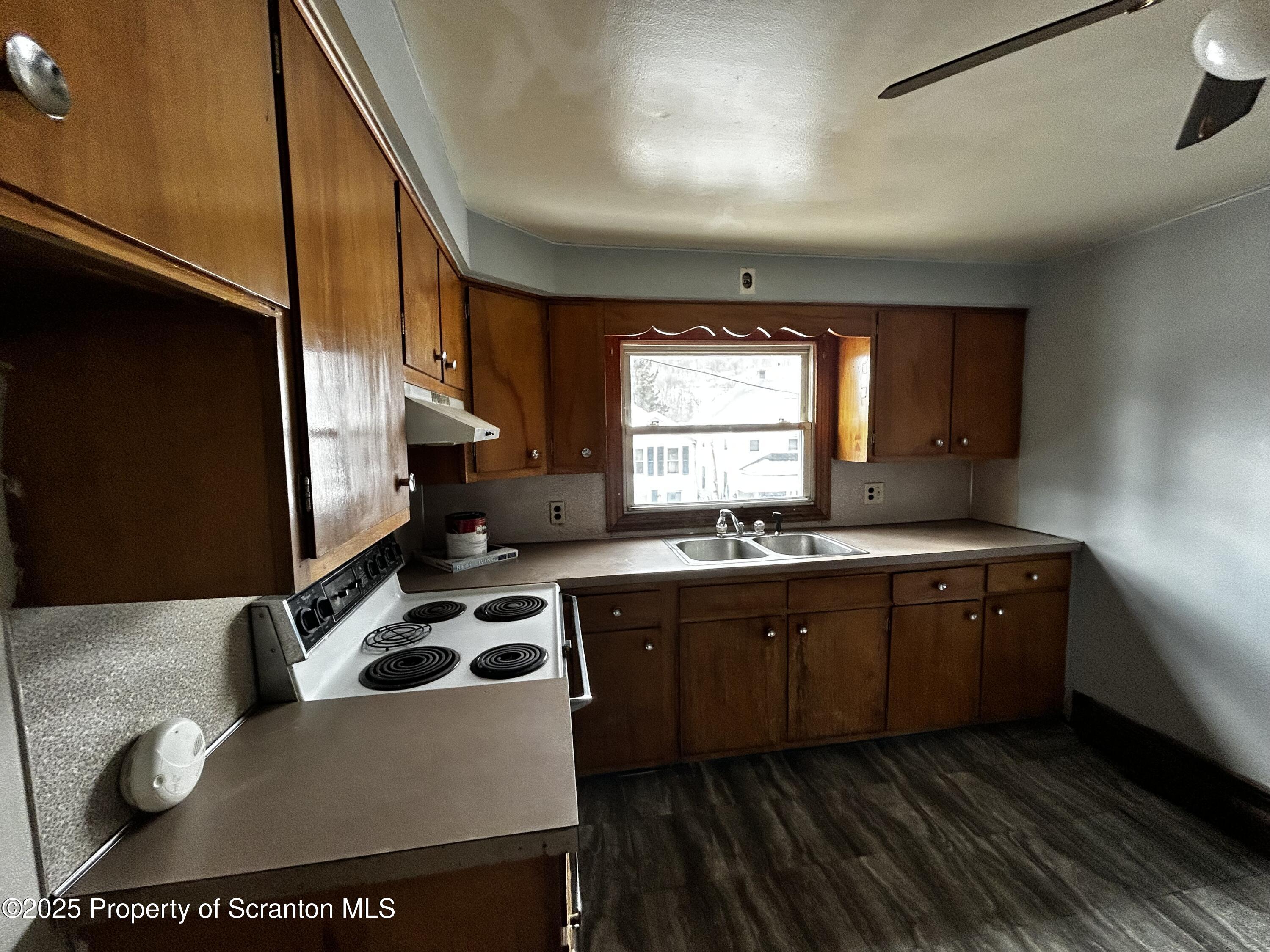 716 Main Street Carbondale, PA 18407 - Photo 5 of 9 a kitchen with a sink a stove cabinets and a window