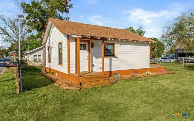 a view of a house with backyard and sitting area