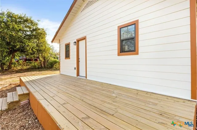 a view of backyard with wooden floor and fence