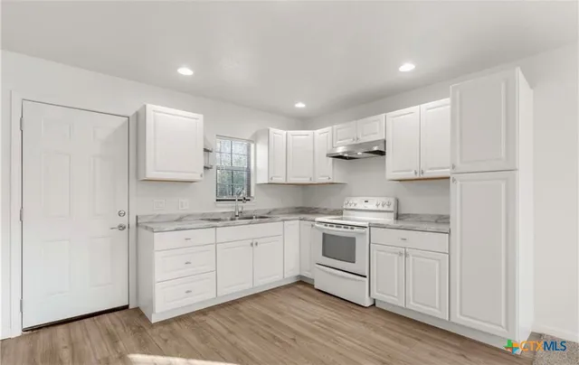 a kitchen with stainless steel appliances granite countertop a sink and cabinets