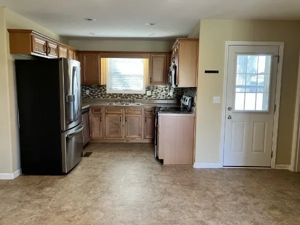 a kitchen with stainless steel appliances granite countertop a refrigerator a stove and a refrigerator