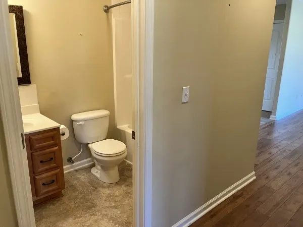 a white toilet sitting next to a shower