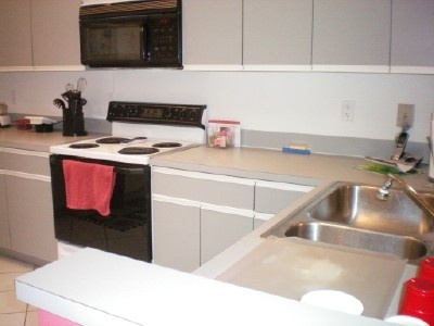 9998 Seacrest Circle, Unit B Boynton Beach, FL 33437 - Photo 12 of 23 a kitchen with a sink cabinets and appliances