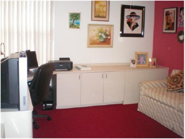 9998 Seacrest Circle, Unit B Boynton Beach, FL 33437 - Photo 20 of 23 a bedroom with a bed and cabinets