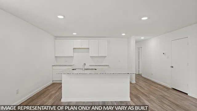 a view of kitchen with white cabinets appliances and wooden floor