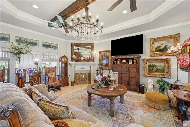 a living room with furniture a flat screen tv and a chandelier