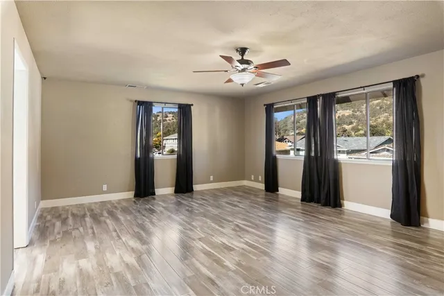 a view of a room with wooden floor and windows