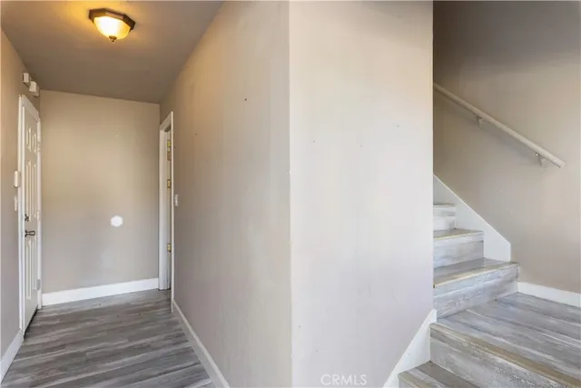 a living room with furniture kitchen view and a wooden floor