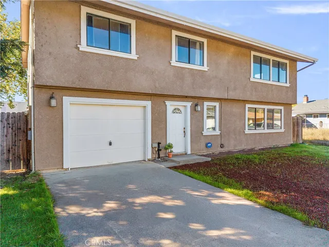 an aerial view of residential houses with outdoor space and trees