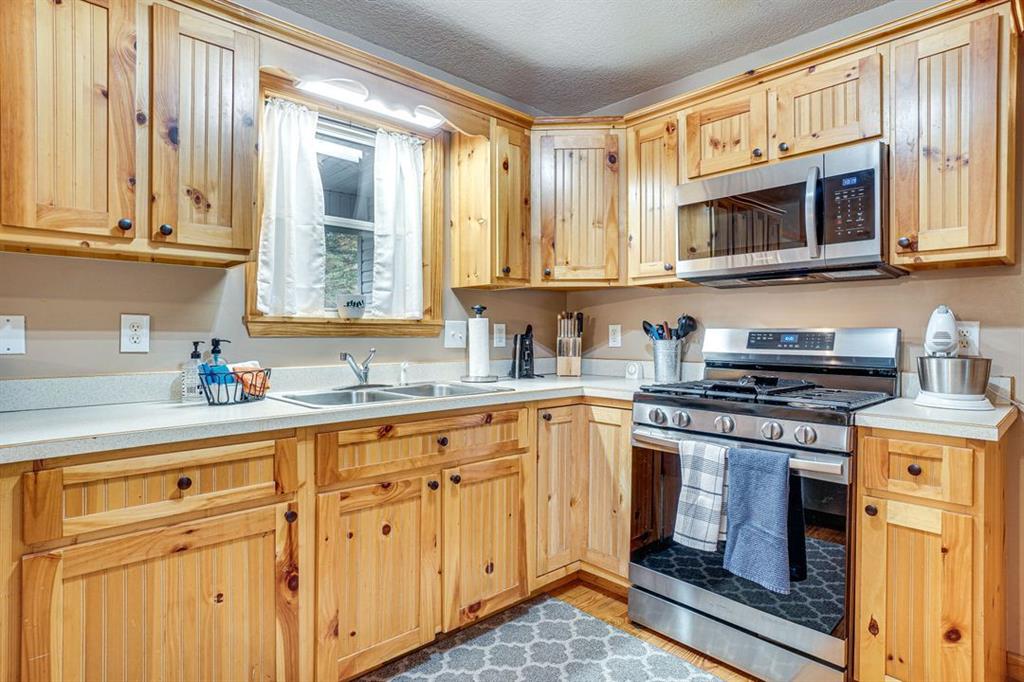 697 Zeppelin Strasse Helen, GA 30545 - Photo 8 of 41 a kitchen with stainless steel appliances granite countertop white cabinets and a stove top oven