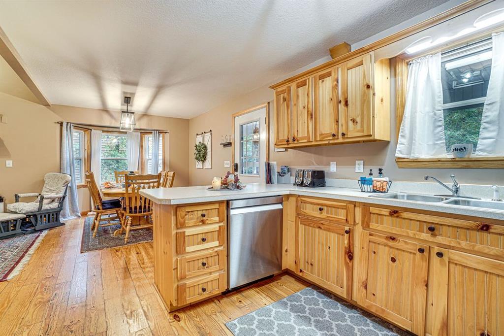 697 Zeppelin Strasse Helen, GA 30545 - Photo 9 of 41 a kitchen with stainless steel appliances granite countertop a stove top oven a sink dishwasher and white cabinets with wooden floor