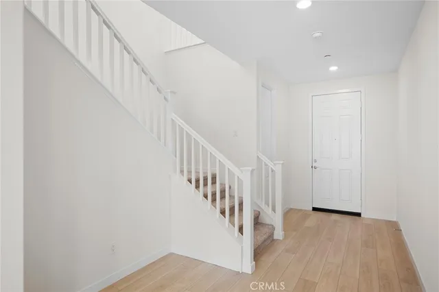 a view of staircase with wooden floor and white walls