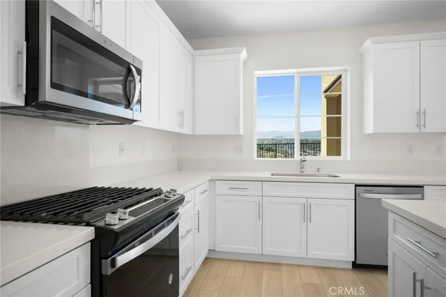 a kitchen with white cabinets and appliances