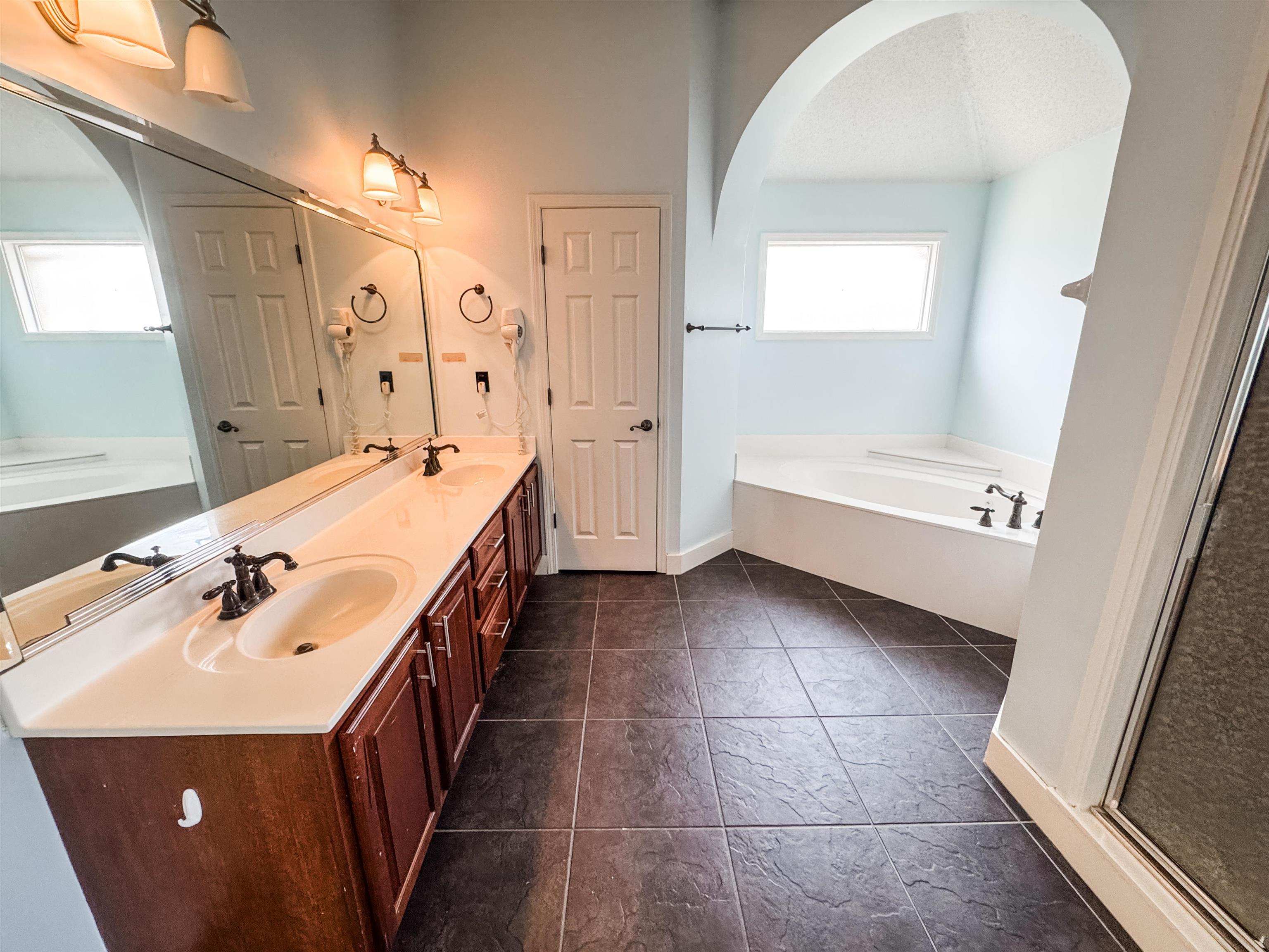 10521 Red Stone Drive Collierville, TN 38017 - Photo 10 of 15 a bathroom with a double vanity sink large mirror and a bathtub