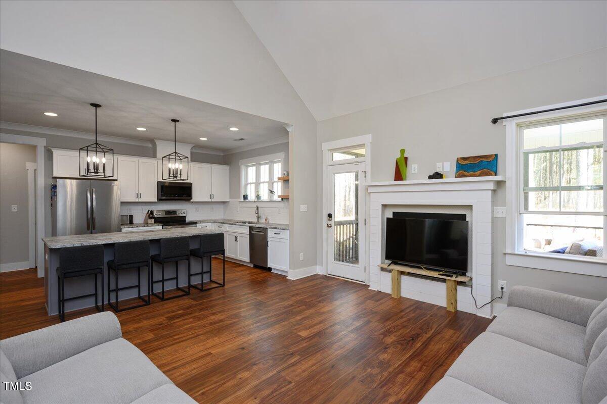 1415 Pine Ridge Road Spring Hope, NC 27882 - Photo 6 of 25 a living room with furniture a fireplace and a flat screen tv
