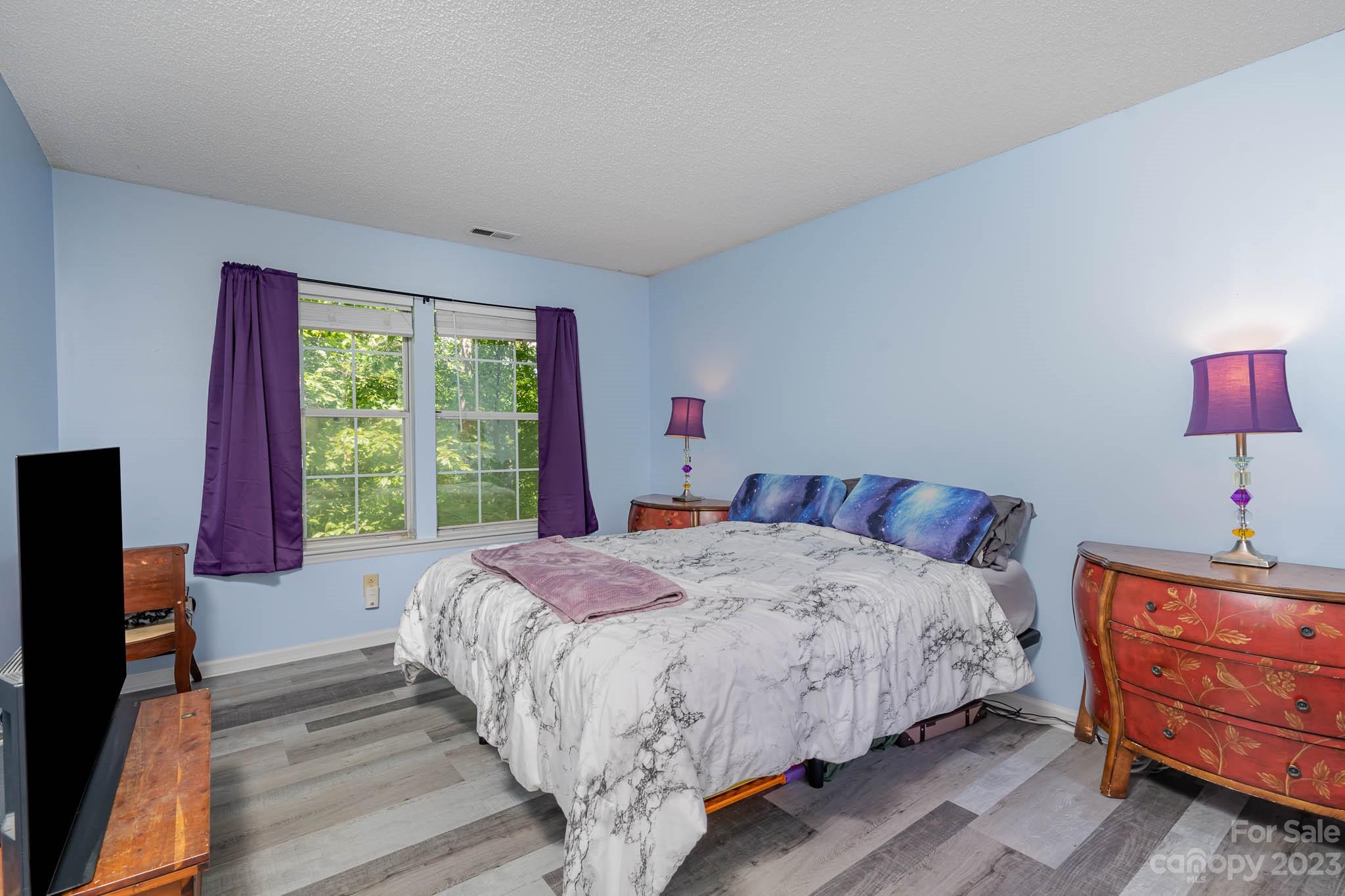 6523 Clavell Lane, Unit E Charlotte, NC 28210 - Photo 14 of 24 a bedroom with a bed and wooden floor