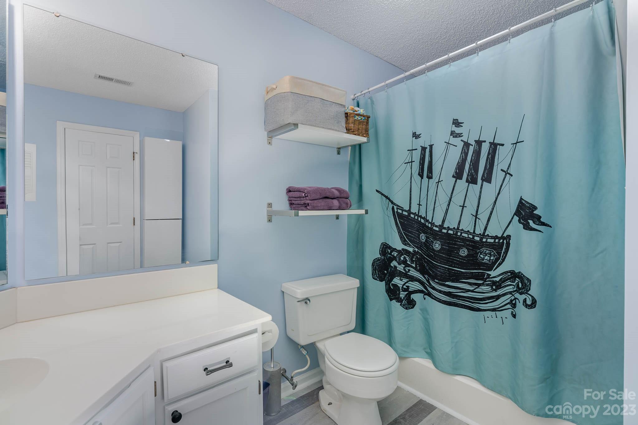6523 Clavell Lane, Unit E Charlotte, NC 28210 - Photo 19 of 24 a bathroom with a toilet a sink and a mirror