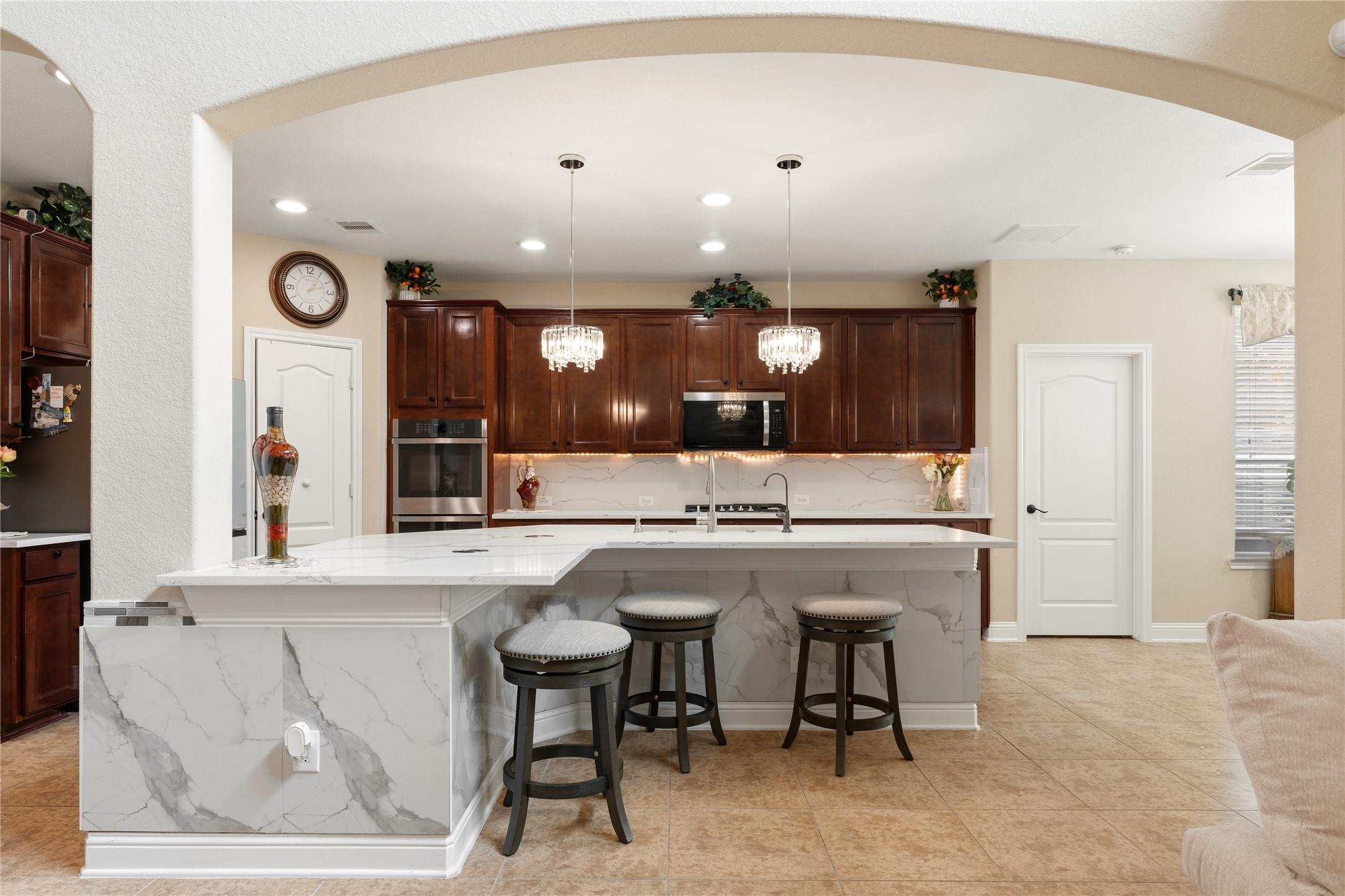 5802 Layton Meadows Lane Spring, TX 77379 - Photo 11 of 42 Kitchen from arched entry. Shot through the arched doorway showing the island, chandeliers, and full kitchen.