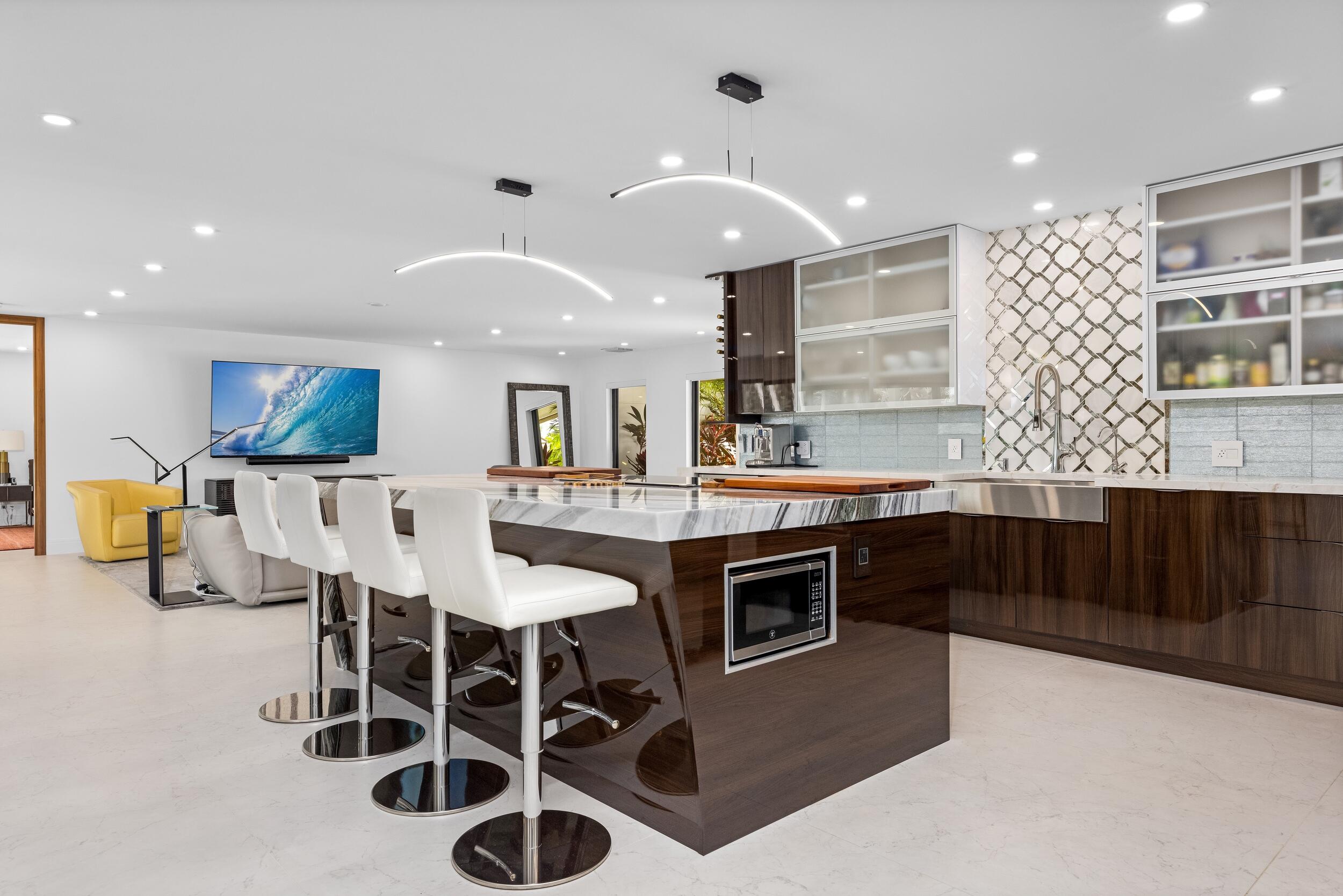 843 Northeast Mulberry Drive Boca Raton, FL 33487 - Photo 15 of 57 a kitchen with stainless steel appliances kitchen island granite countertop a table and chairs in it