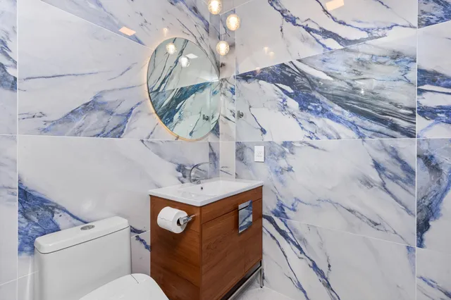 a bathroom with a toilet sink and mirror