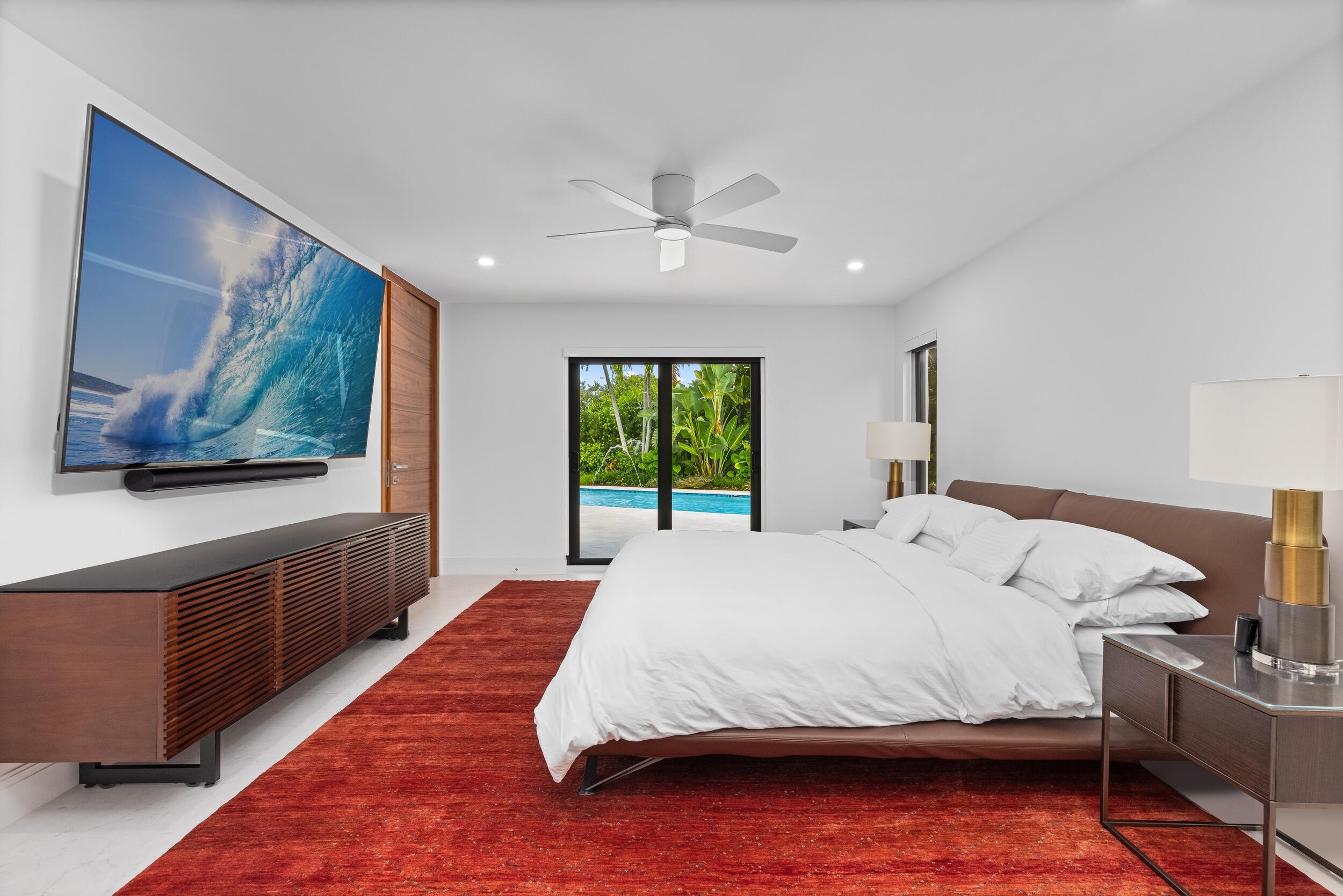 843 Northeast Mulberry Drive Boca Raton, FL 33487 - Photo 24 of 57 a bedroom with a large bed and a chandelier