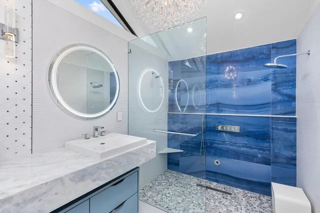 a bathroom with a granite countertop sink a mirror and shower