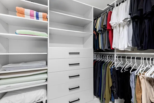 a view of walk in closet with clothes and shoes