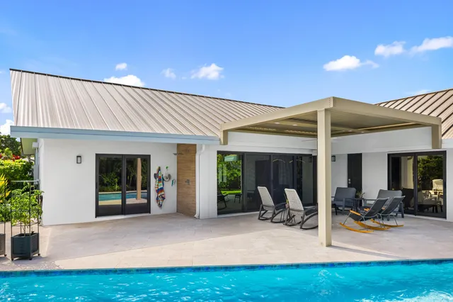 a view of a house with swimming pool and sitting area