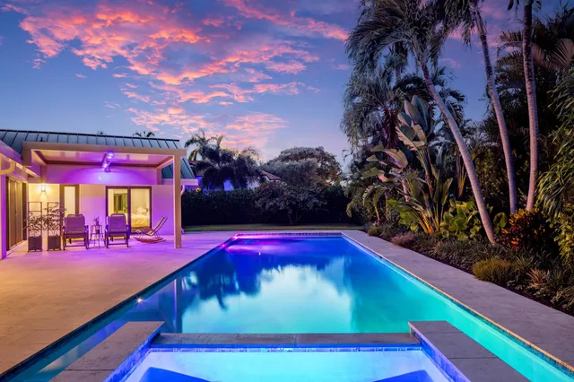 a view of swimming pool with lawn chairs under an umbrella