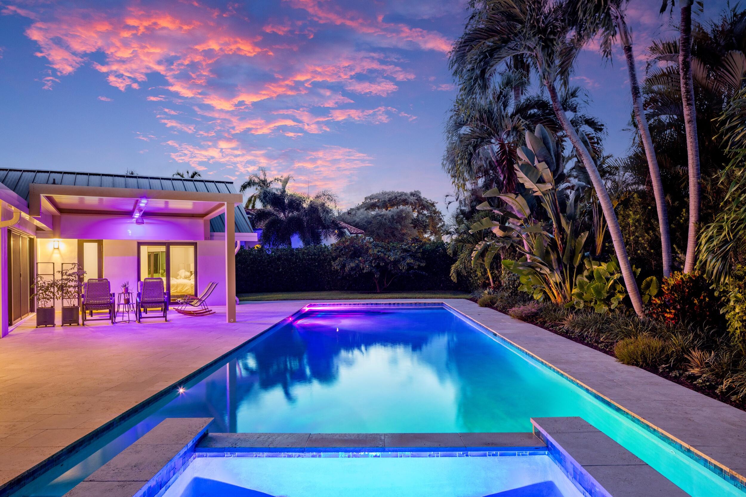 843 Northeast Mulberry Drive Boca Raton, FL 33487 - Photo 4 of 57 a view of swimming pool with lawn chairs under an umbrella