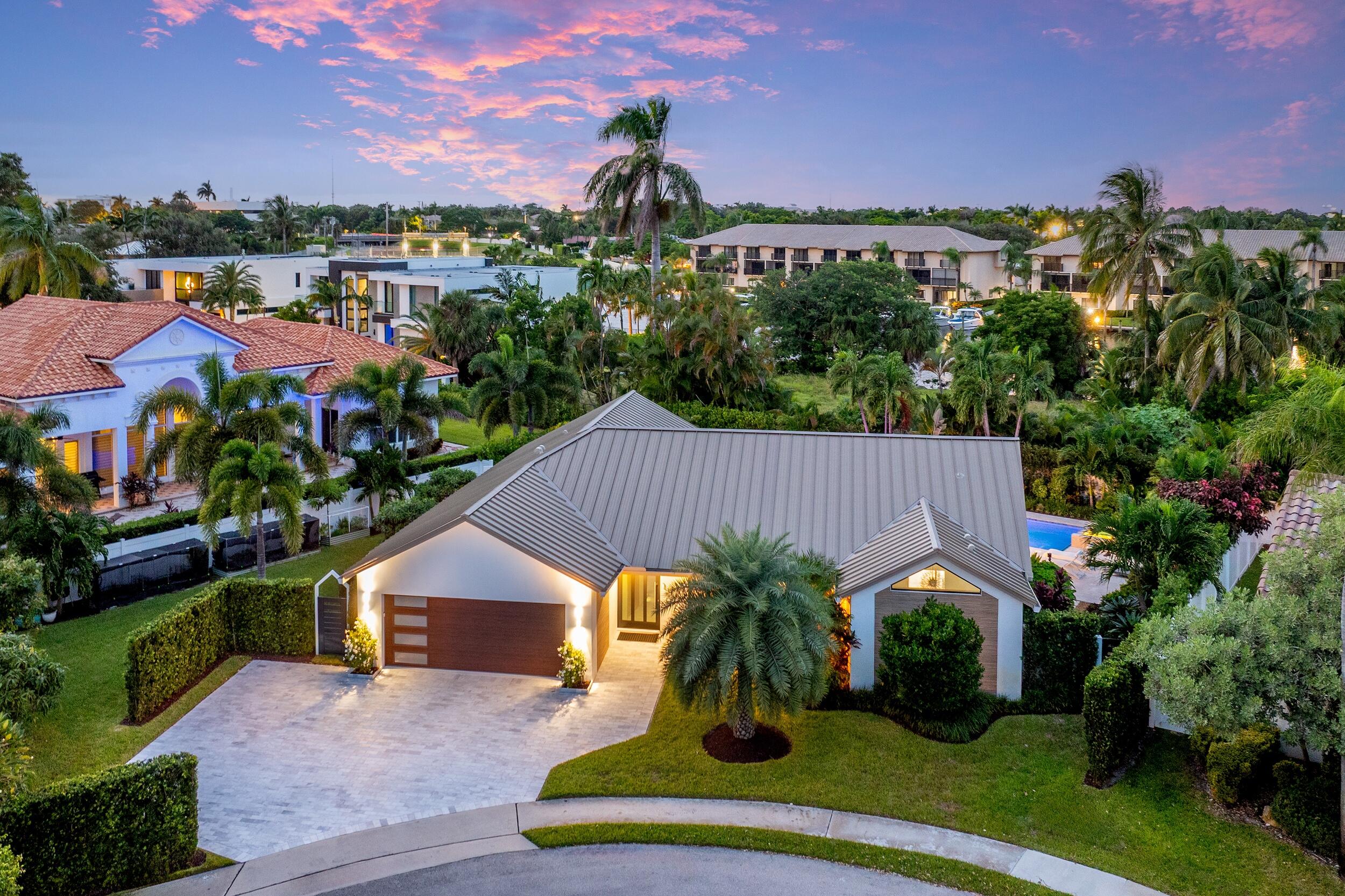 843 Northeast Mulberry Drive Boca Raton, FL 33487 - Photo 47 of 57 a front view of a house with a yard and potted plants