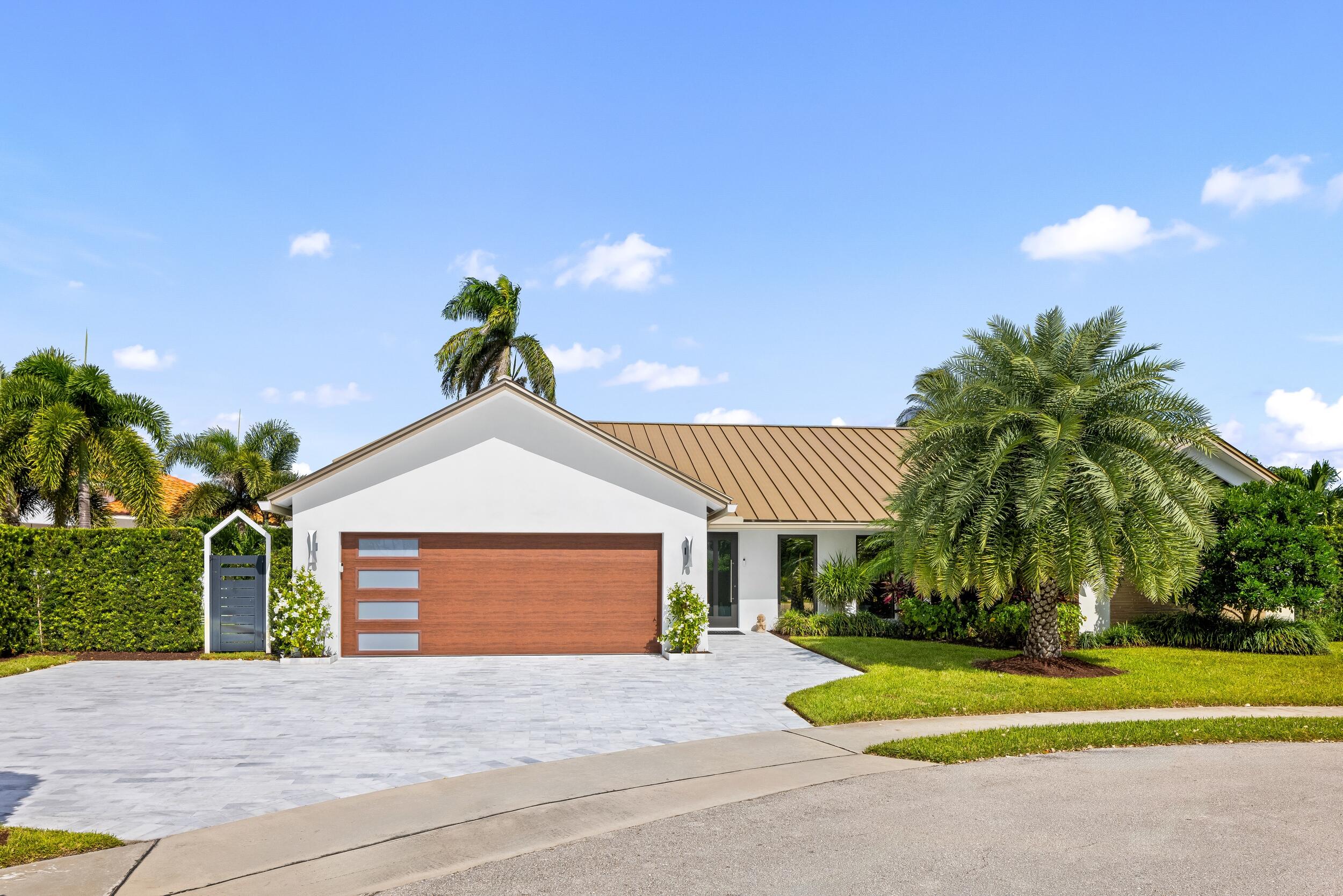 843 Northeast Mulberry Drive Boca Raton, FL 33487 - Photo 48 of 57 a front view of a house with a yard and garage