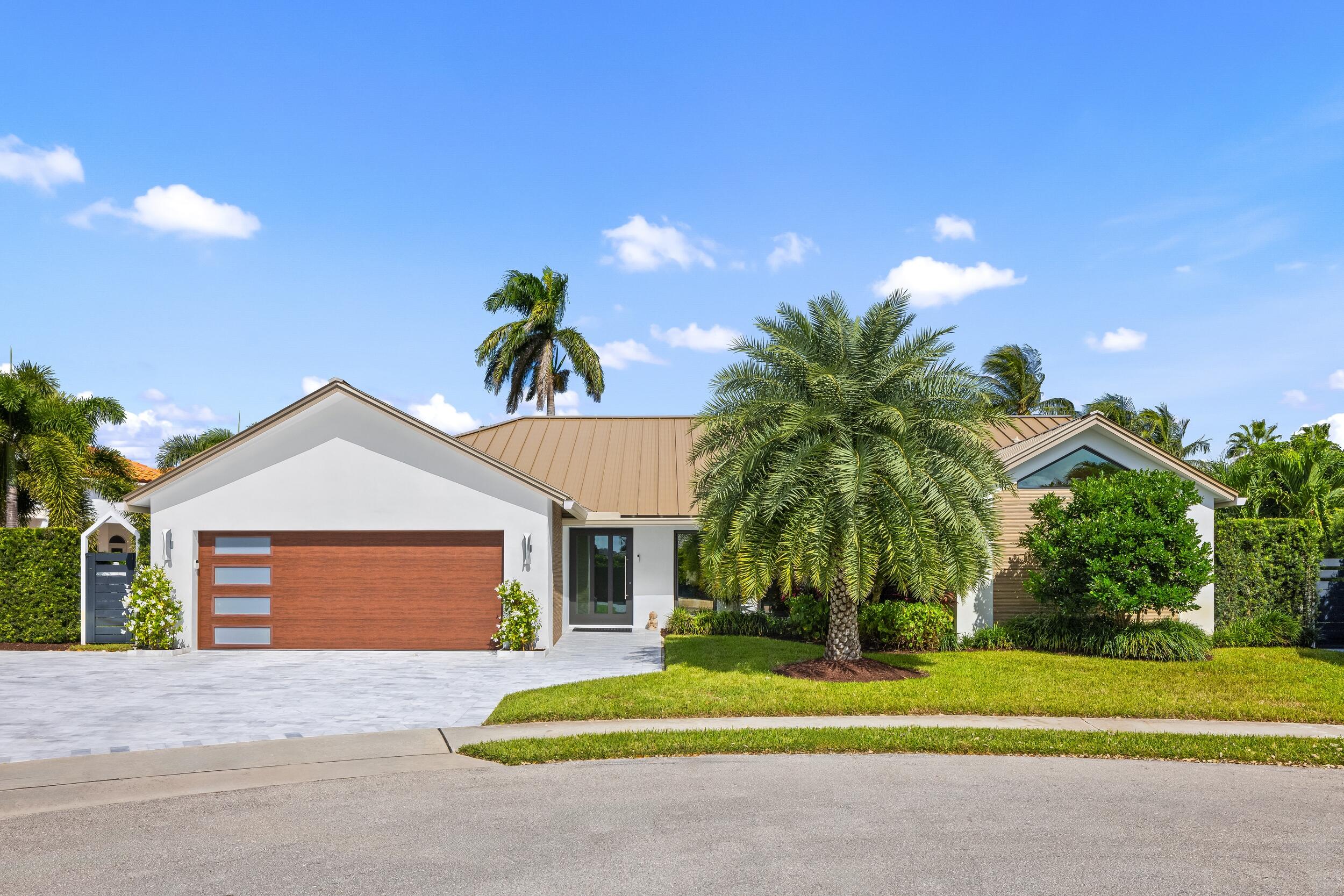 843 Northeast Mulberry Drive Boca Raton, FL 33487 - Photo 6 of 57 a front view of a house with a yard and garage