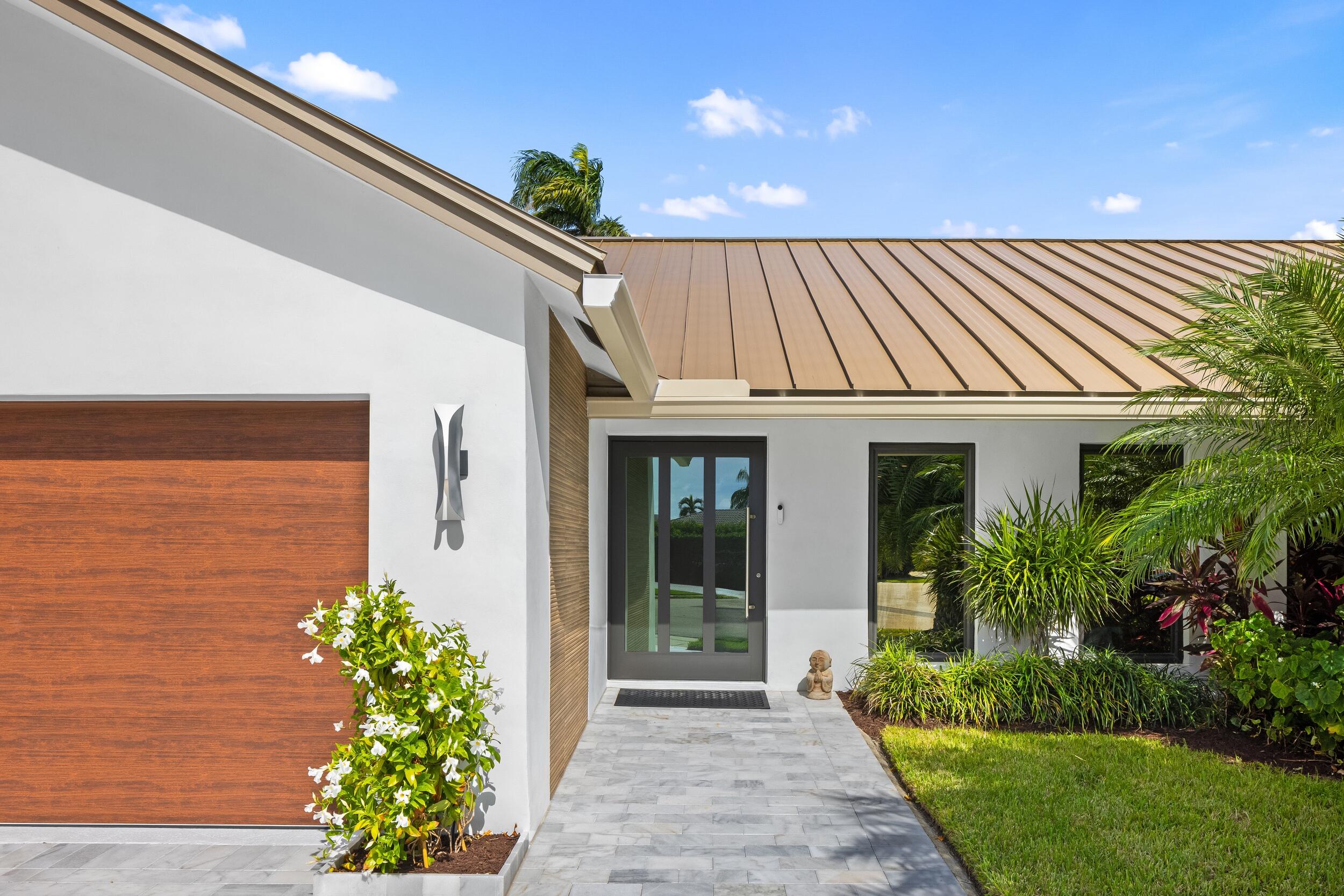 843 Northeast Mulberry Drive Boca Raton, FL 33487 - Photo 7 of 57 a front view of a house with a garden