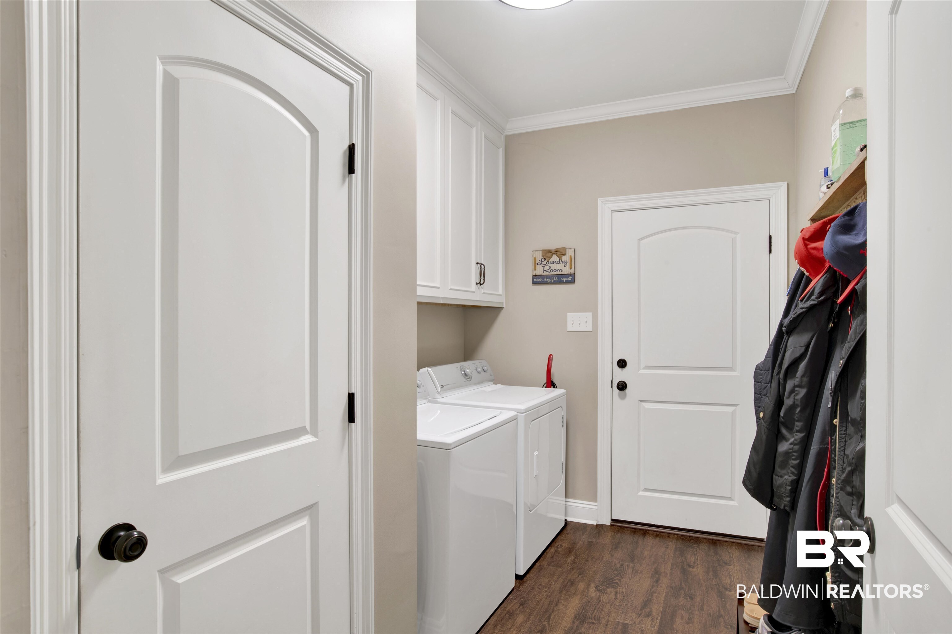 2440 Johnson Road West Mobile, AL 36695 - Photo 19 of 40 Laundry area featuring cabinets, dark hardwood / wood-style flooring, crown molding, and washing machine and clothes dryer