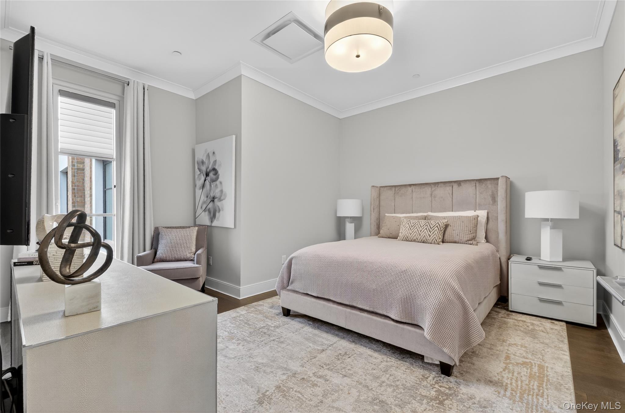 100 Garvies Point Road, Unit 1332 Glen Cove, NY 11542 - Photo 17 of 45 a bedroom with a bed and a chandelier