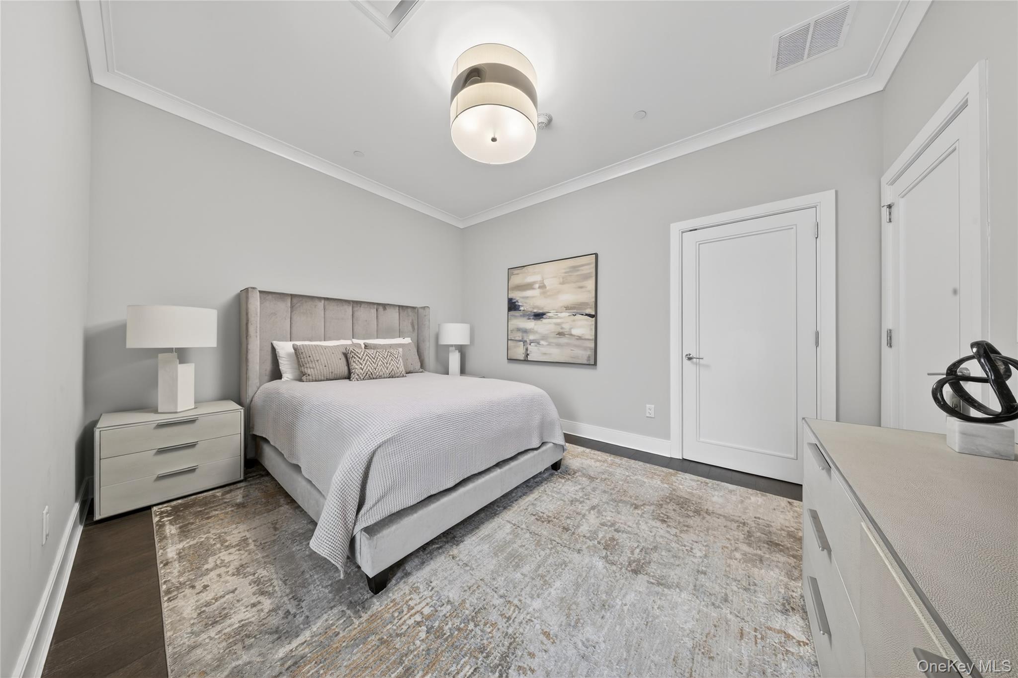100 Garvies Point Road, Unit 1332 Glen Cove, NY 11542 - Photo 18 of 45 a bedroom with a bed and a chandelier