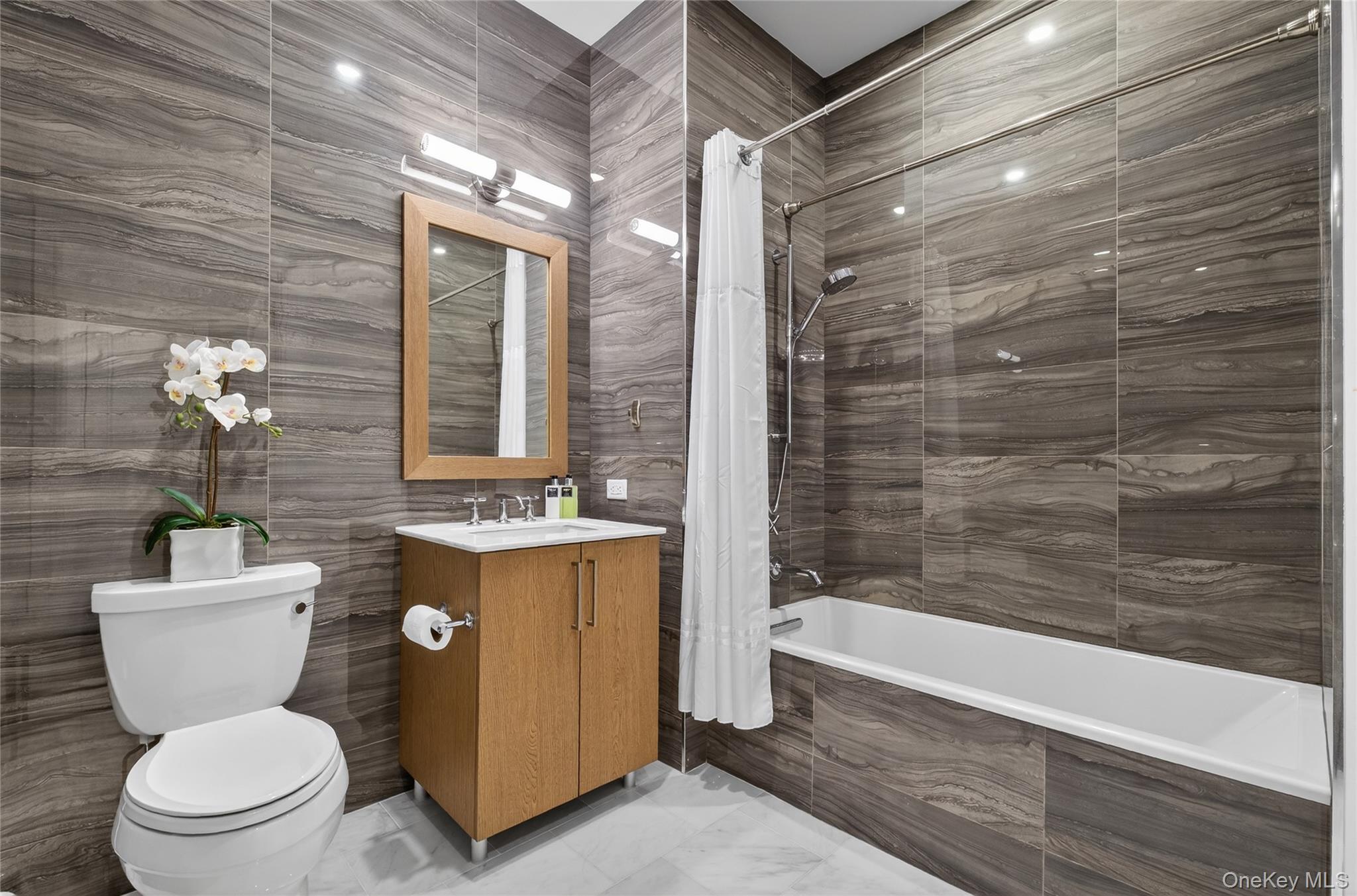 100 Garvies Point Road, Unit 1332 Glen Cove, NY 11542 - Photo 21 of 45 a bathroom with a granite countertop toilet a sink and bathtub